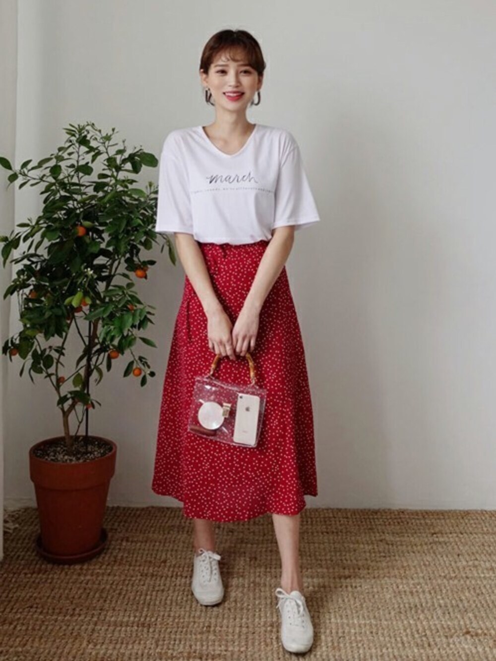 レッド系のスカート、ホワイト系のTシャツ/カットソー、シルバー系のピアス(両耳用)を着用したレディースの春コーディネートの1枚目の写真