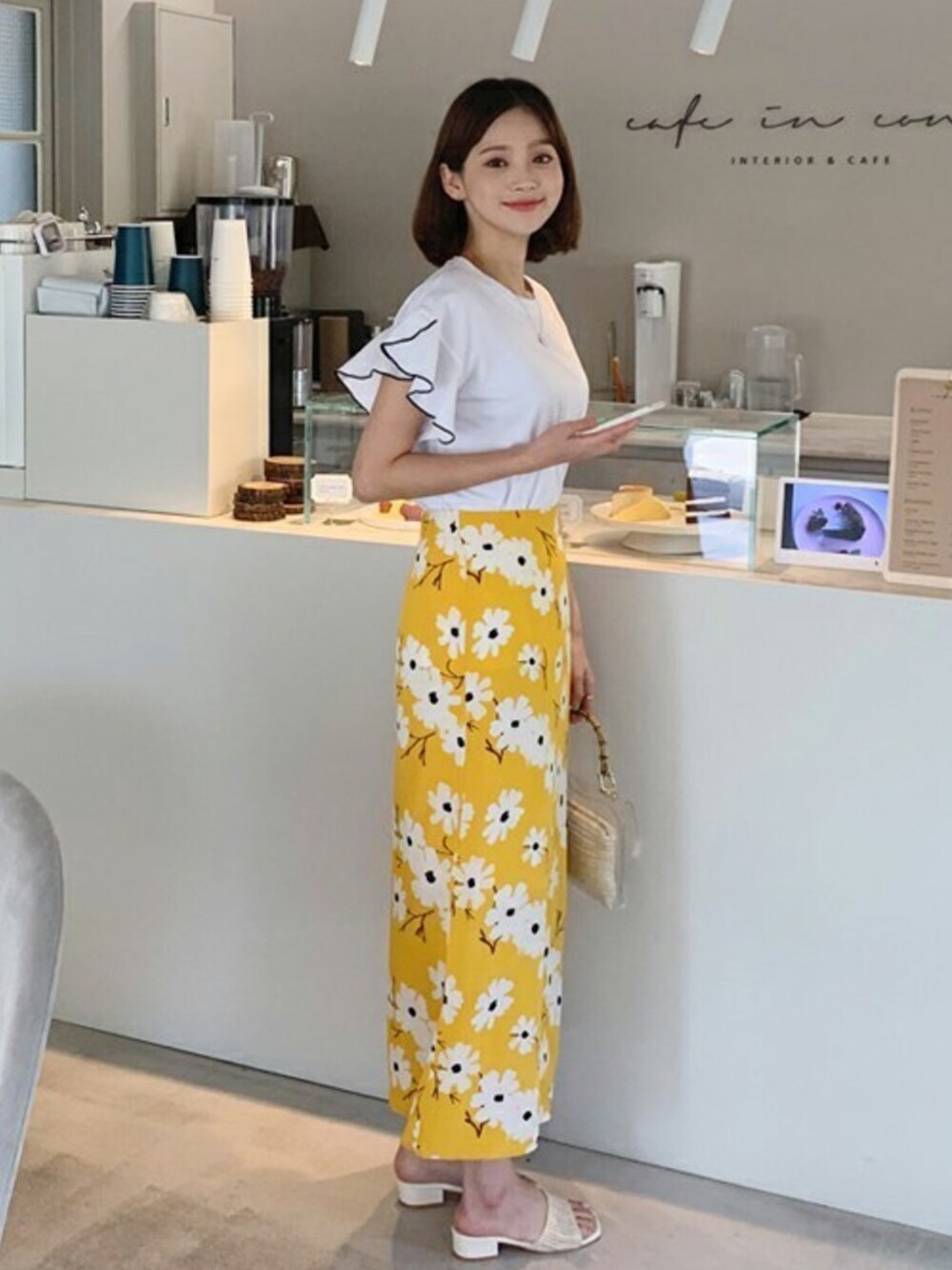 ホワイト系のTシャツ/カットソー、イエロー系のスカートを着用したレディースの春コーディネートの1枚目の写真