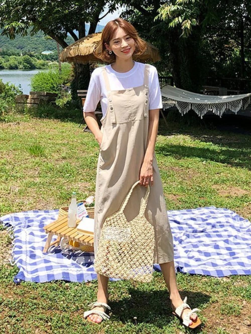 ベージュ系のワンピース、グリーン系のサンダルを着用したレディースの夏コーディネートの1枚目の写真