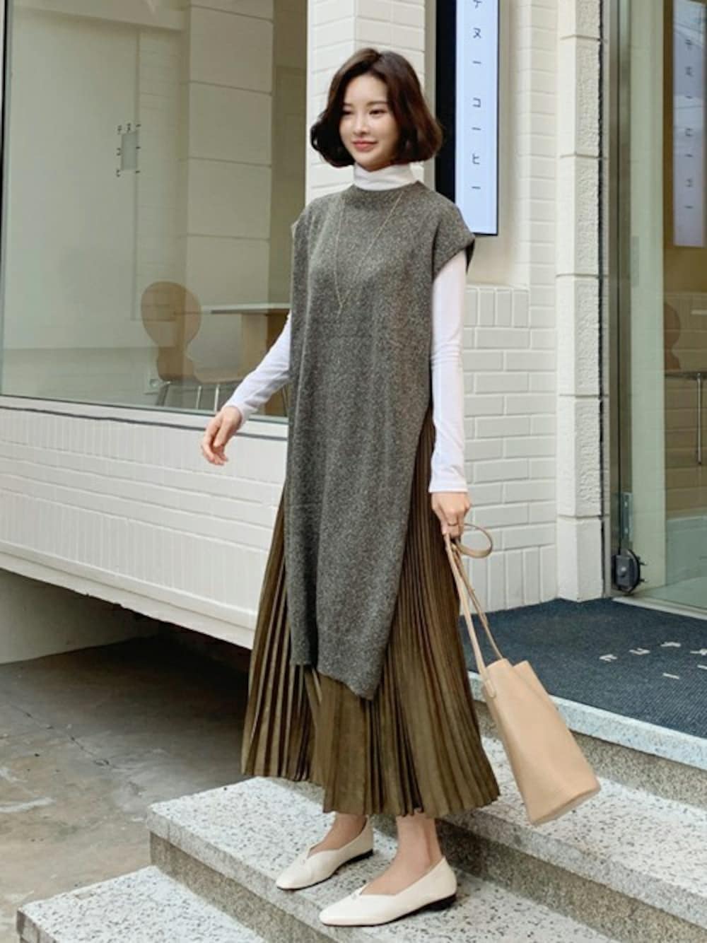 グリーン系のベスト、ホワイト系のTシャツ/カットソー、グリーン系のその他パンツを着用したレディースの秋コーディネートの1枚目の写真