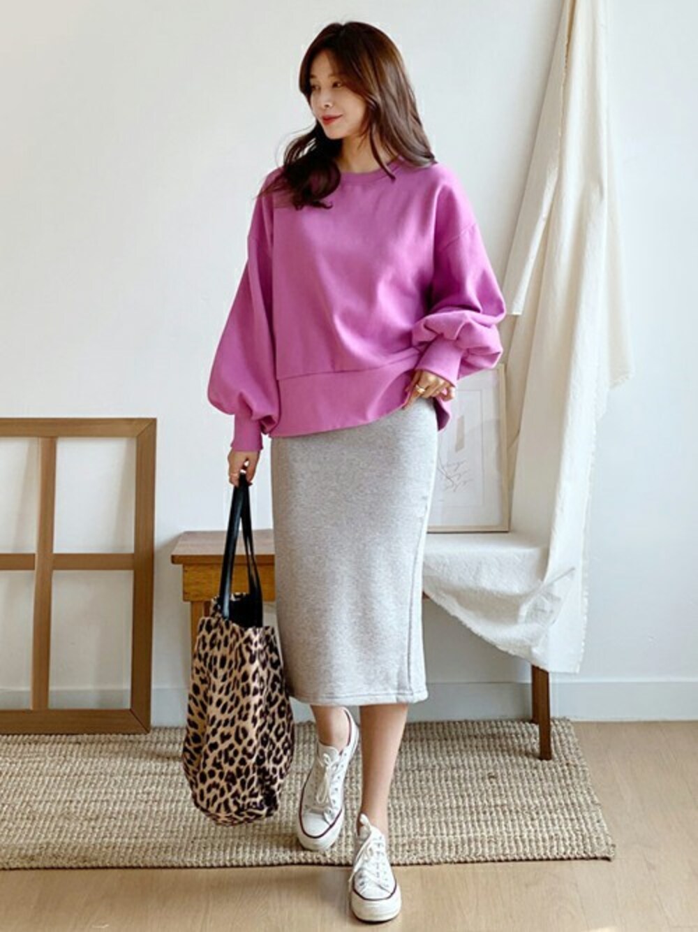 ピンク系のスウェット、グレー系のスカート、ブラウン系のトートバッグを着用したレディースの秋コーディネートの1枚目の写真