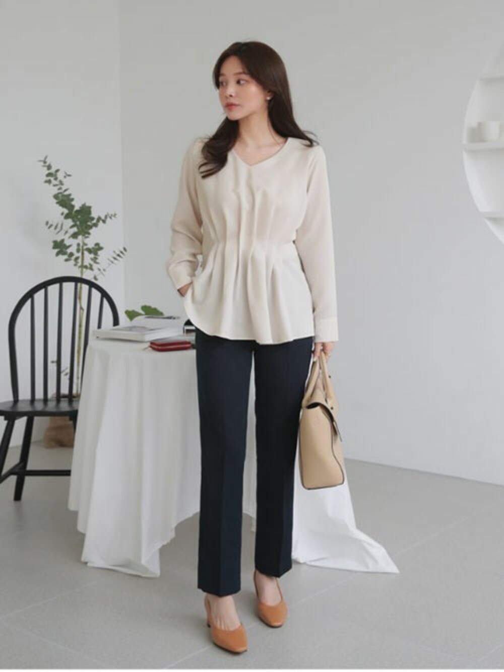 ベージュ系のシャツ/ブラウス、ブラック系のスラックス、シルバー系のリングを着用したレディースの冬コーディネートの1枚目の写真