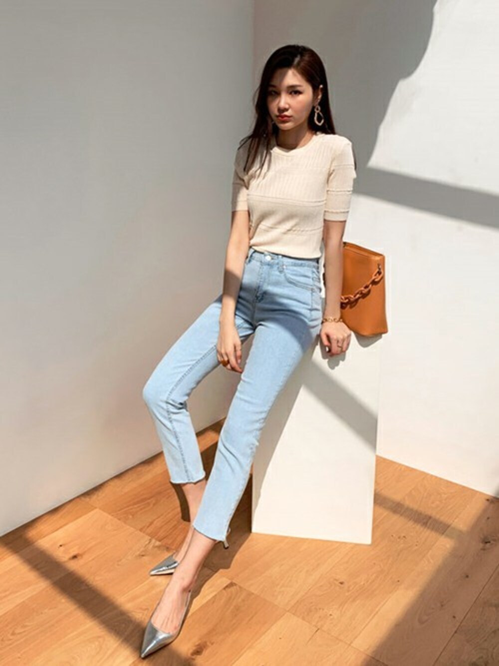 ブルー系のデニムパンツ、ベージュ系のニット/セーターを着用したレディースの春コーディネートの1枚目の写真