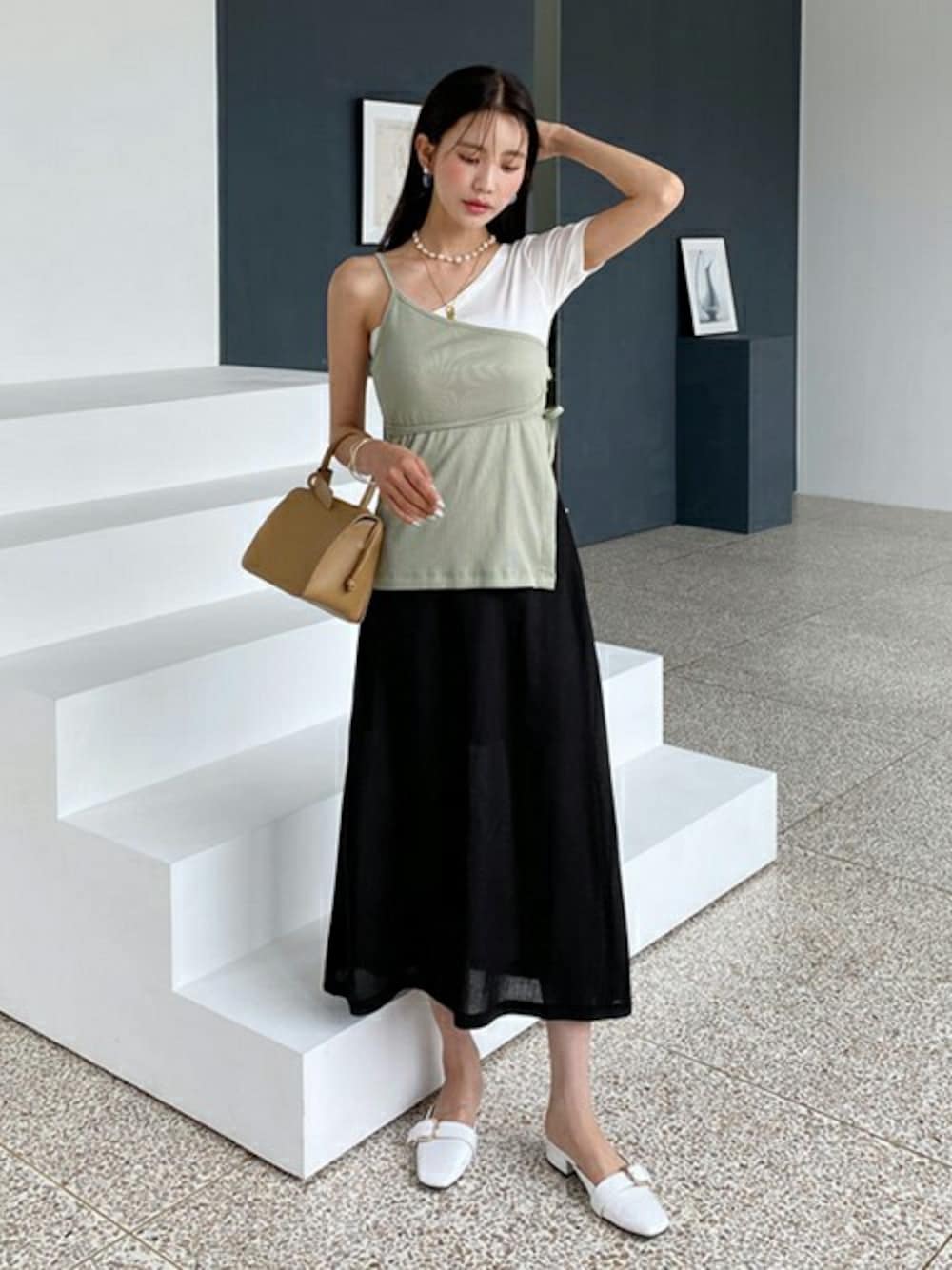 グリーン系のキャミソール、ホワイト系のTシャツ/カットソー、ブラック系のスカートを着用したレディースの春コーディネートの1枚目の写真