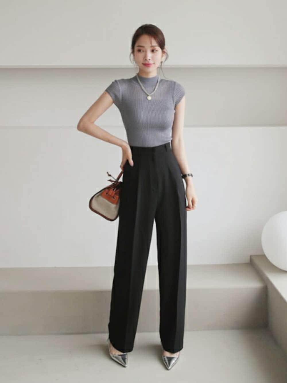 ブルー系のニット/セーター、グレー系のスラックス、ホワイト系のその他を着用したレディースの夏コーディネートの1枚目の写真