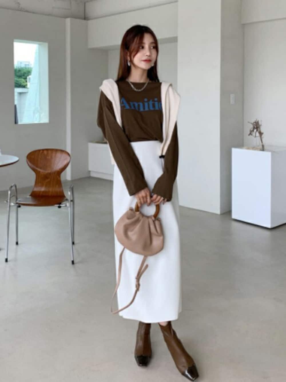 ブラウン系のTシャツ/カットソー、ホワイト系のスカート、その他のTシャツ/カットソーを着用したレディースの秋コーディネートの1枚目の写真