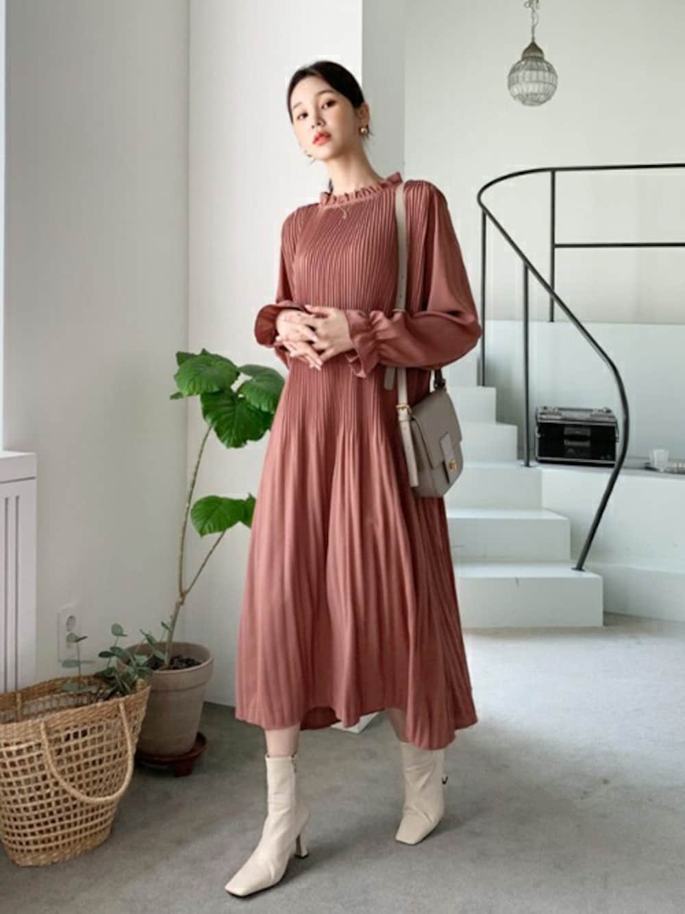 ピンク系のワンピースを着用したレディースの秋コーディネートの1枚目の写真