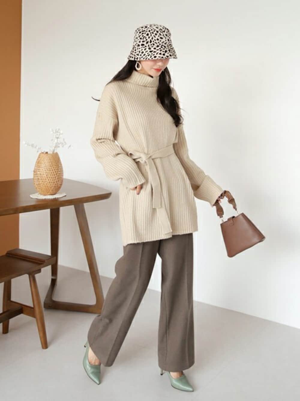 ベージュ系のニット/セーター、ブラウン系のスラックス、その他のTシャツ/カットソーを着用したレディースの秋コーディネートの1枚目の写真