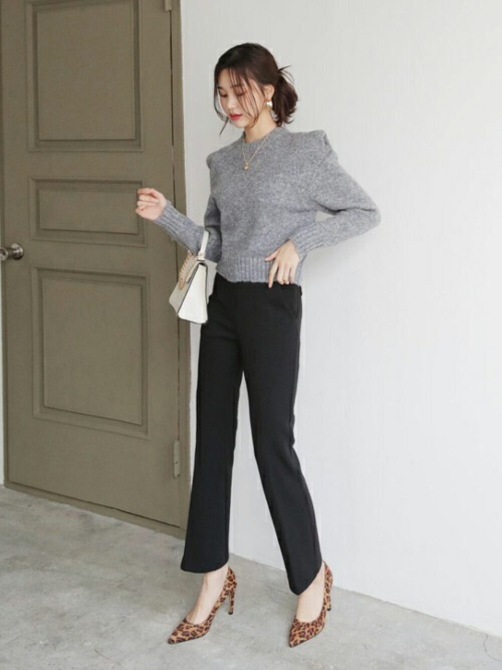 グレー系のニット/セーター、ブラック系のスラックス、その他のTシャツ/カットソーを着用したレディースの秋コーディネートの1枚目の写真