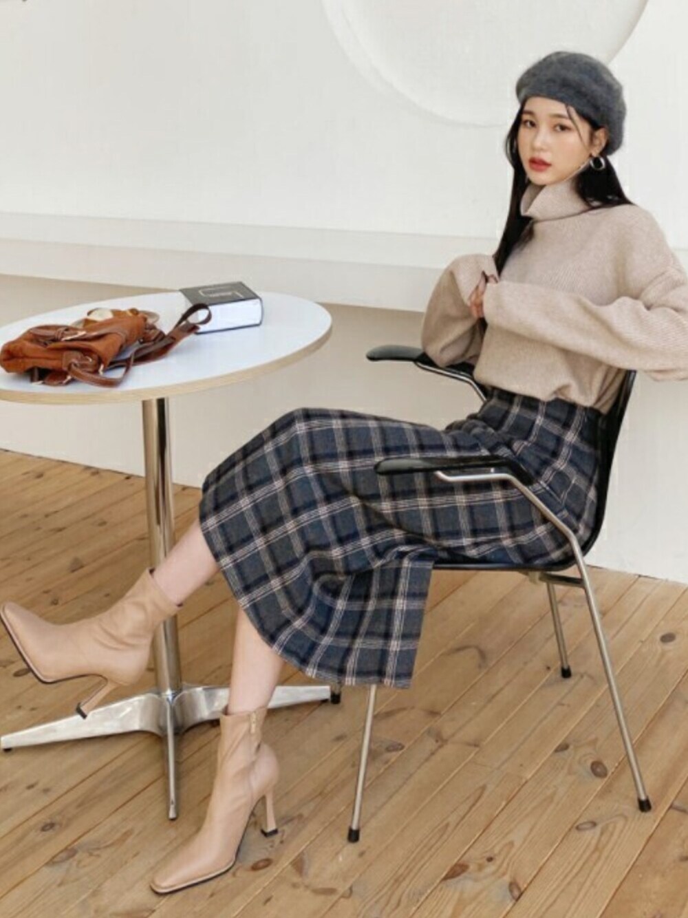 ベージュ系のニット/セーター、グレー系のスカート、その他のTシャツ/カットソーを着用したレディースの冬コーディネートの1枚目の写真