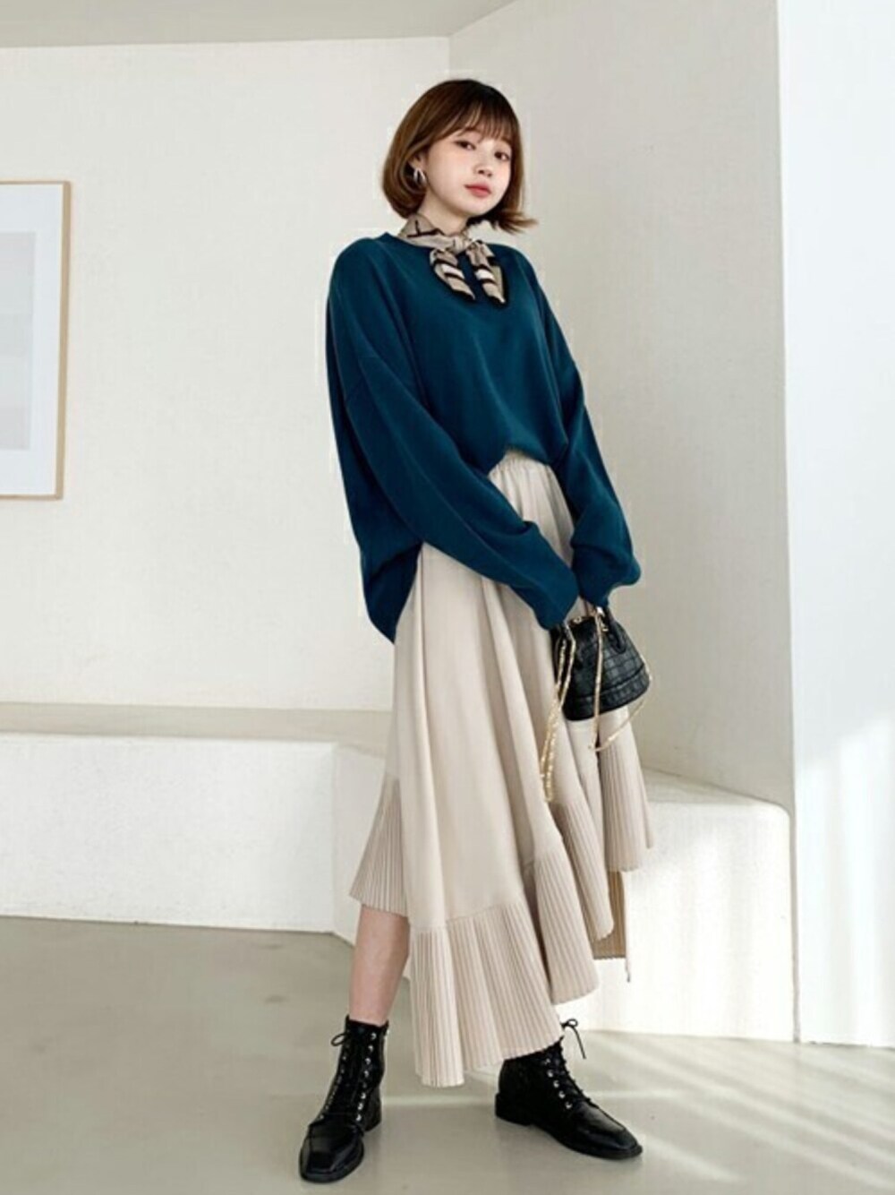 ブルー系のニット/セーター、ベージュ系のスカートを着用したレディースの冬コーディネートの1枚目の写真