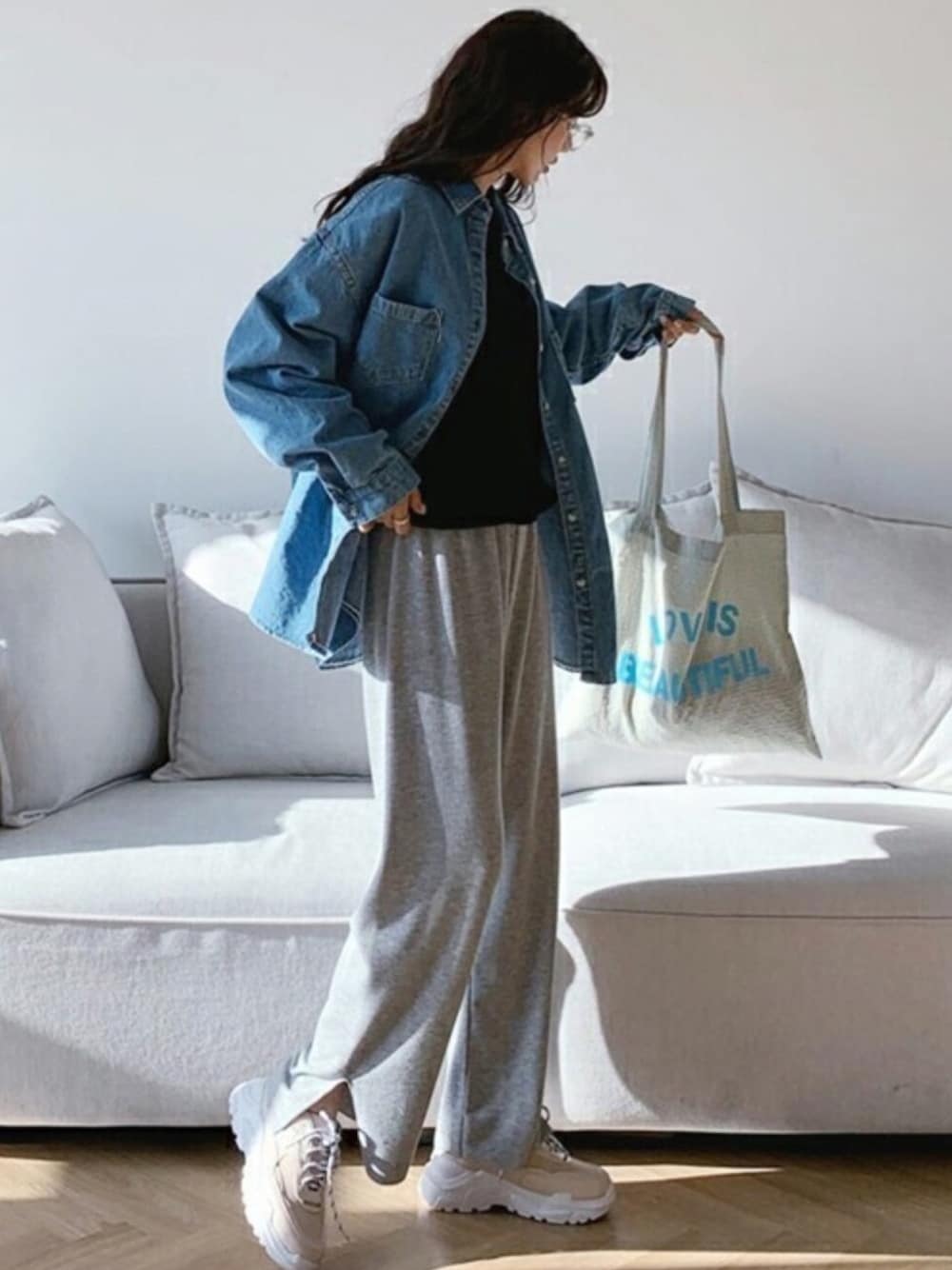 ブルー系のシャツ/ブラウス、ベージュ系のスニーカー、ブラック系のニット/セーターを着用したレディースの冬コーディネートの1枚目の写真