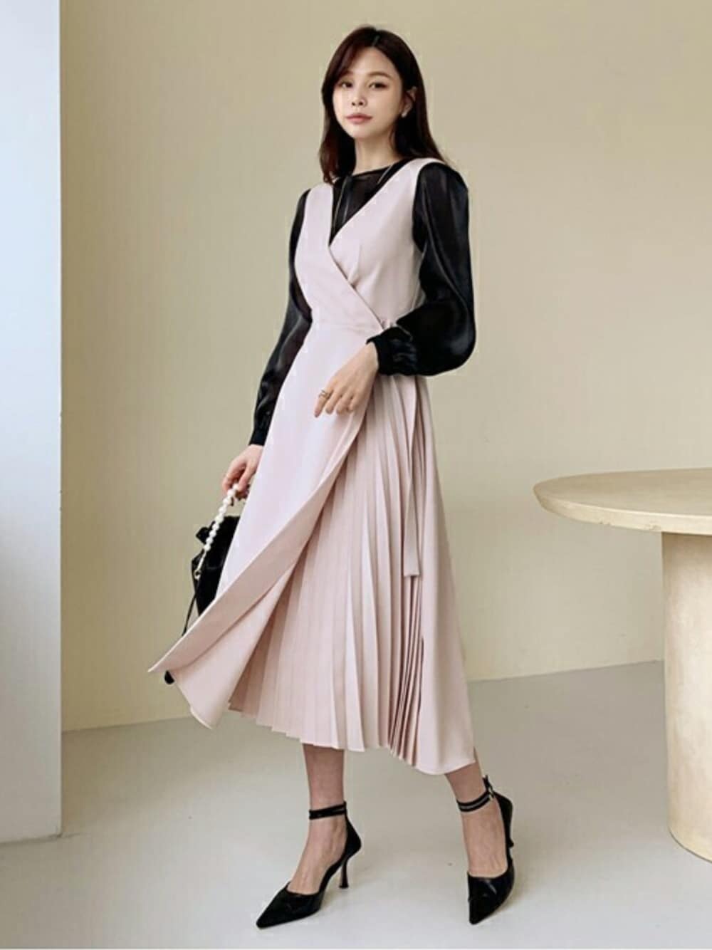 ベージュ系のジャンパースカートを着用したレディースの冬コーディネートの1枚目の写真