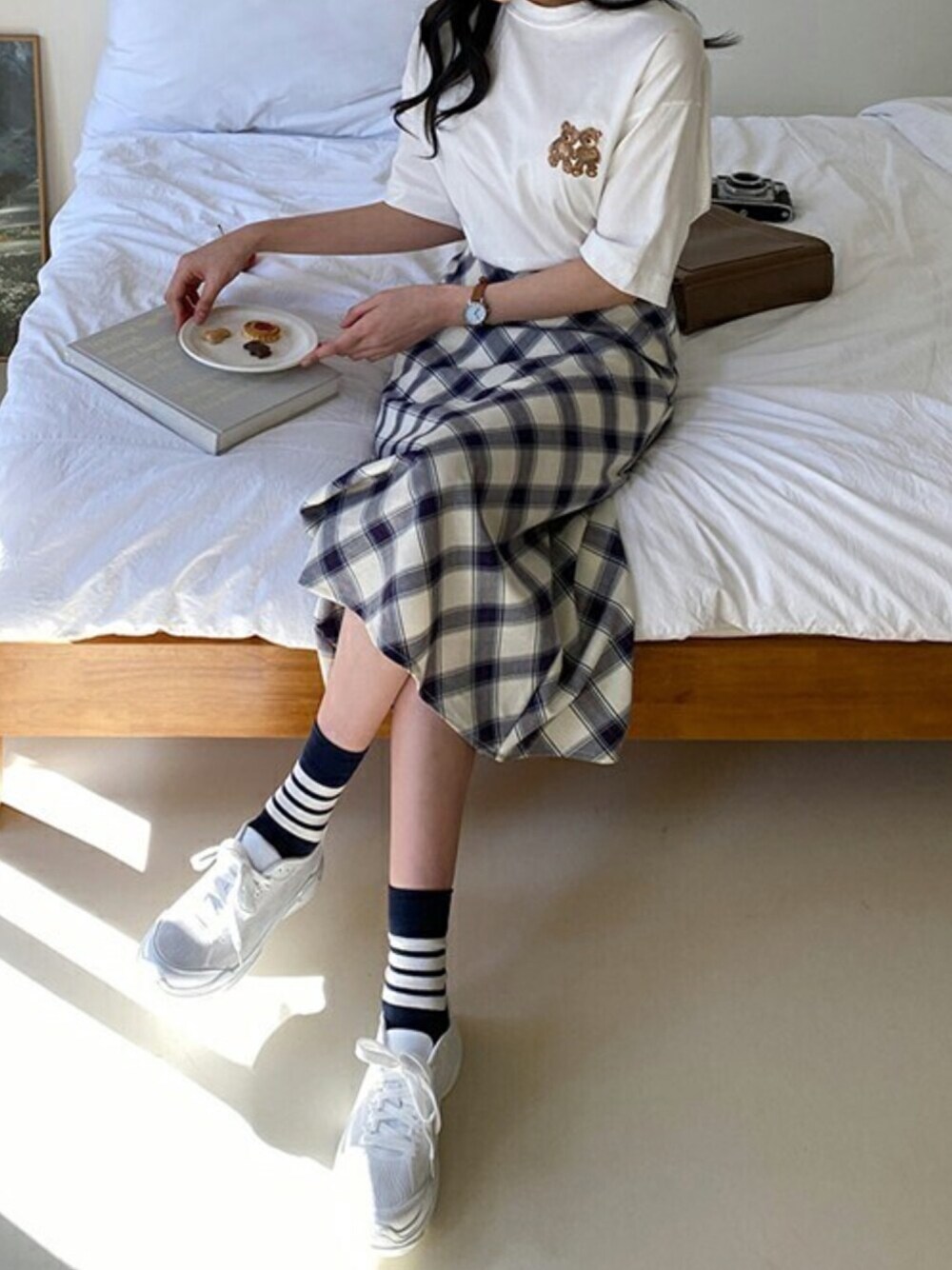 ホワイト系のTシャツ/カットソー、ブルー系のスカート、ホワイト系のスニーカーを着用したレディースの冬コーディネートの1枚目の写真