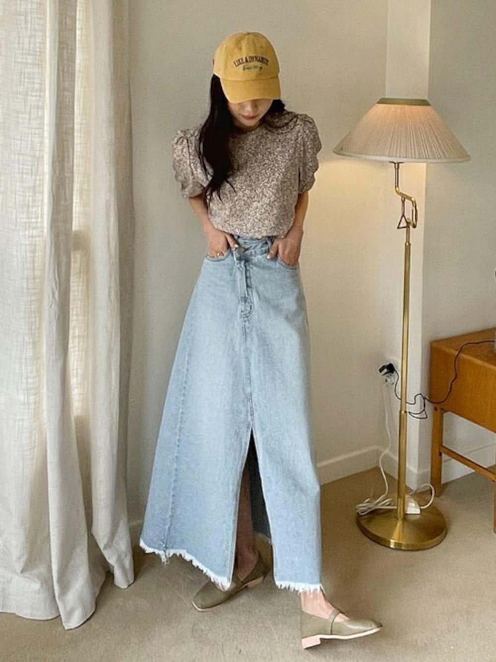 イエロー系のキャップを着用したレディースの春コーディネートの1枚目の写真