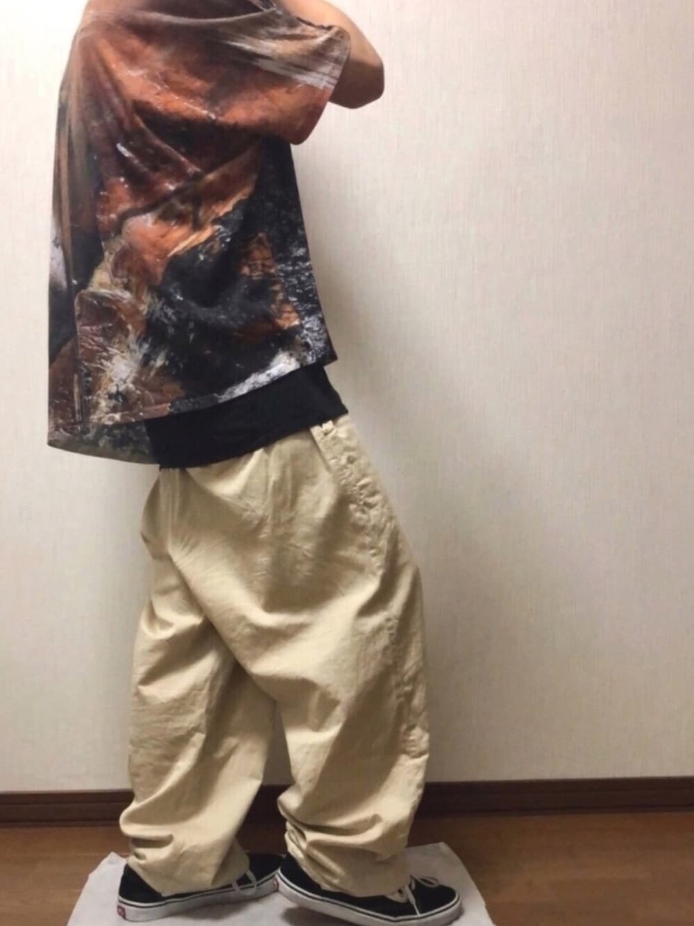 ブラウン系のTシャツ/カットソー、ベージュ系のその他パンツ、ブラック系のスニーカーを着用したメンズの春コーディネートの1枚目の写真