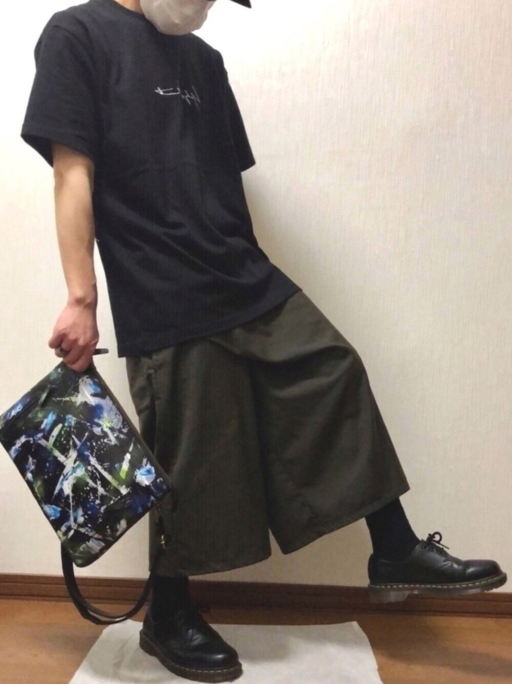 ブラック系のTシャツ/カットソー、グリーン系のパンツ、ブラック系のドレスシューズを着用したメンズの春コーディネートの1枚目の写真