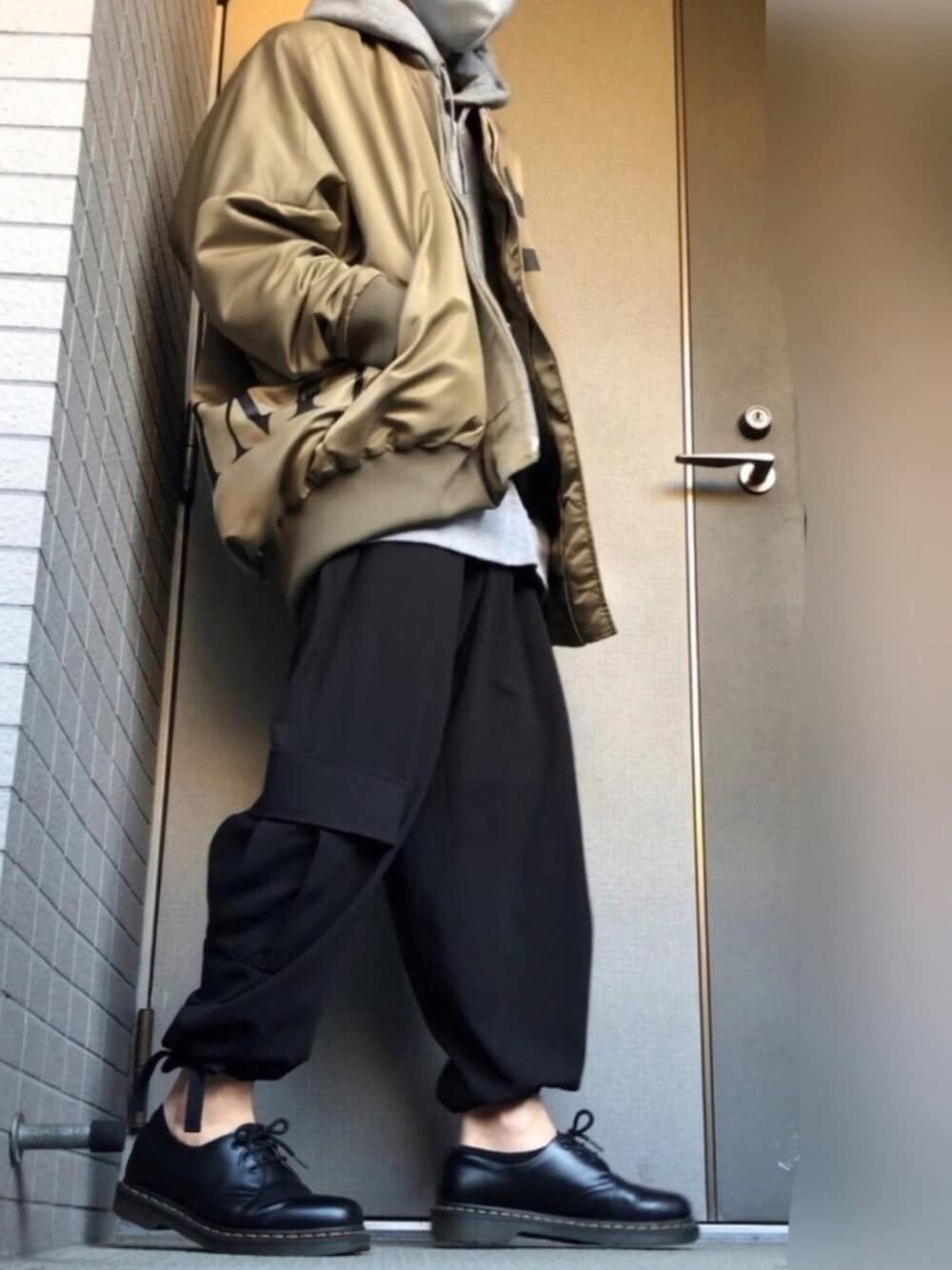 グリーン系のMA-1、グレー系のパーカー、ブラック系のパンツを着用したメンズの秋コーディネートの1枚目の写真