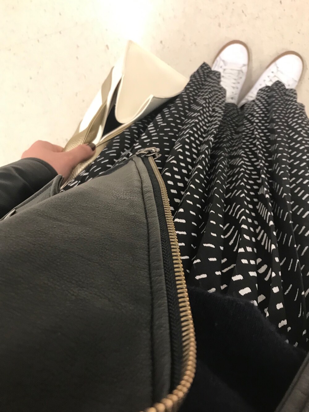 ブラック系のライダースジャケット、ブラック系のスカート、ブルー系のニット/セーターを着用したレディースの冬コーディネートの1枚目の写真