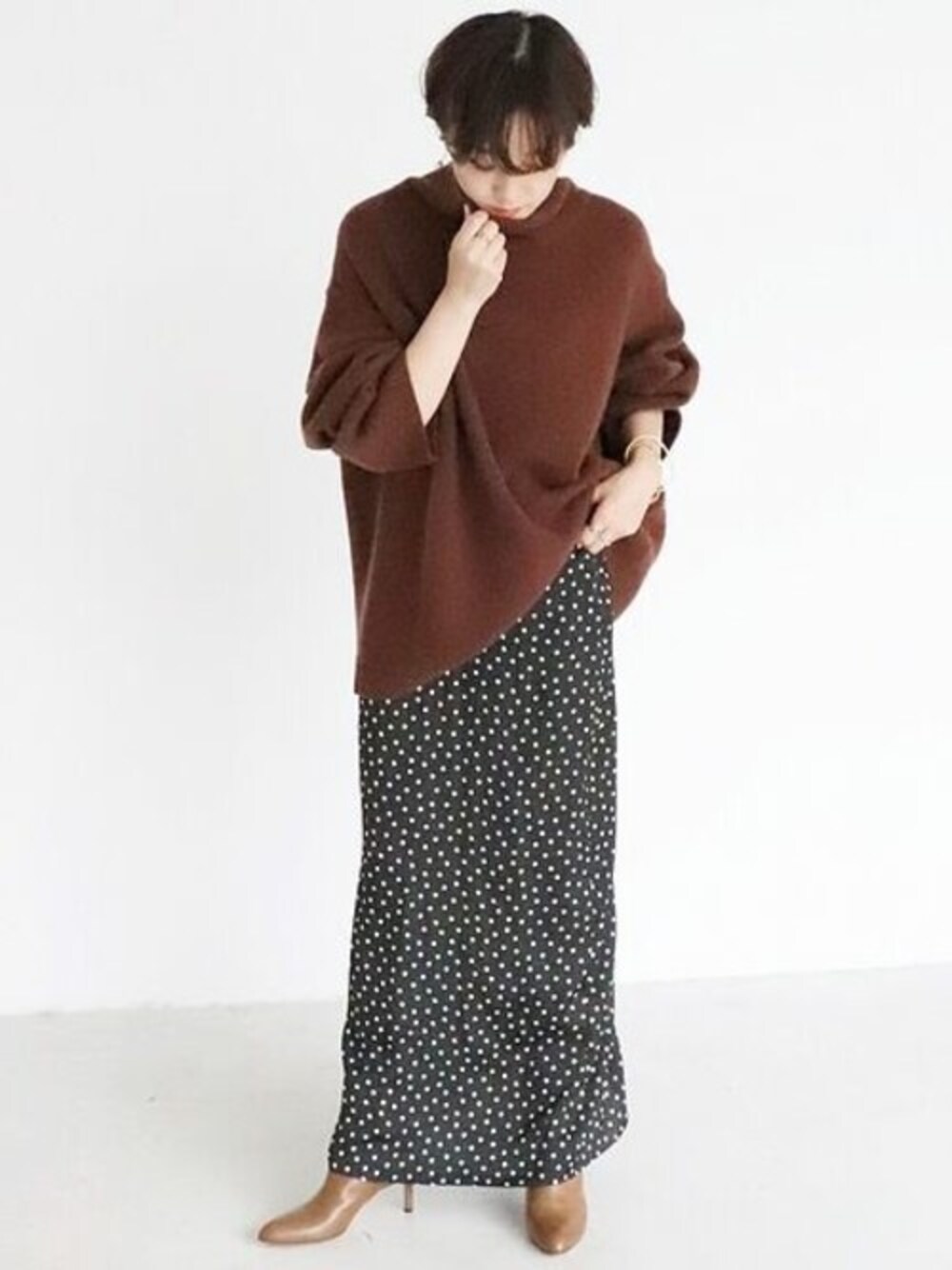 ブラック系のスカート、ブラウン系のニット/セーターを着用したレディースの秋コーディネートの1枚目の写真