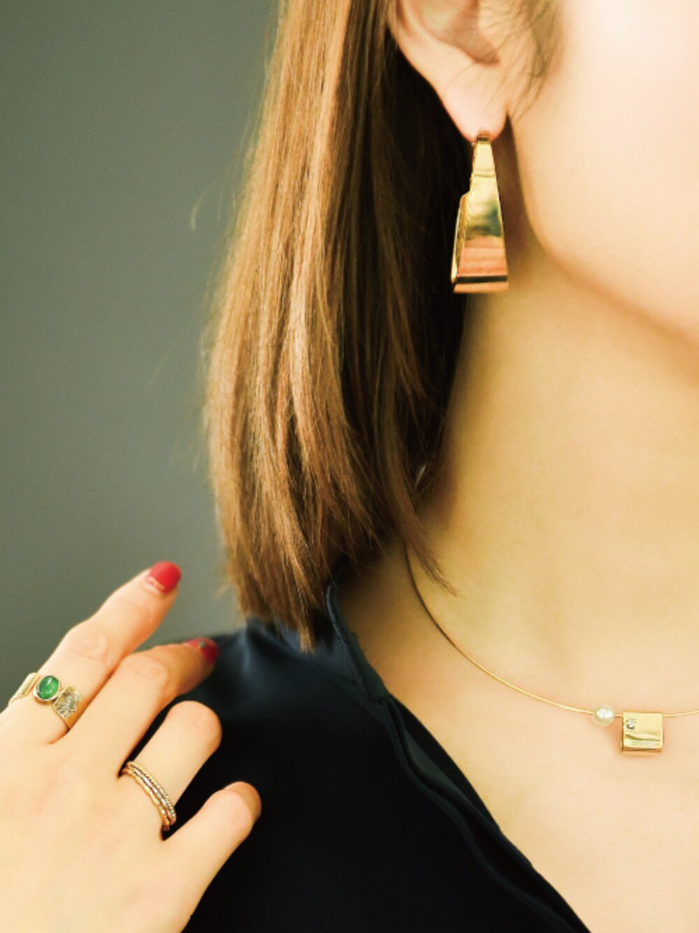 ゴールド系のピアス（両耳用）、ゴールド系のチョーカー、グリーン系のリングを着用したレディースの秋コーディネートの1枚目の写真