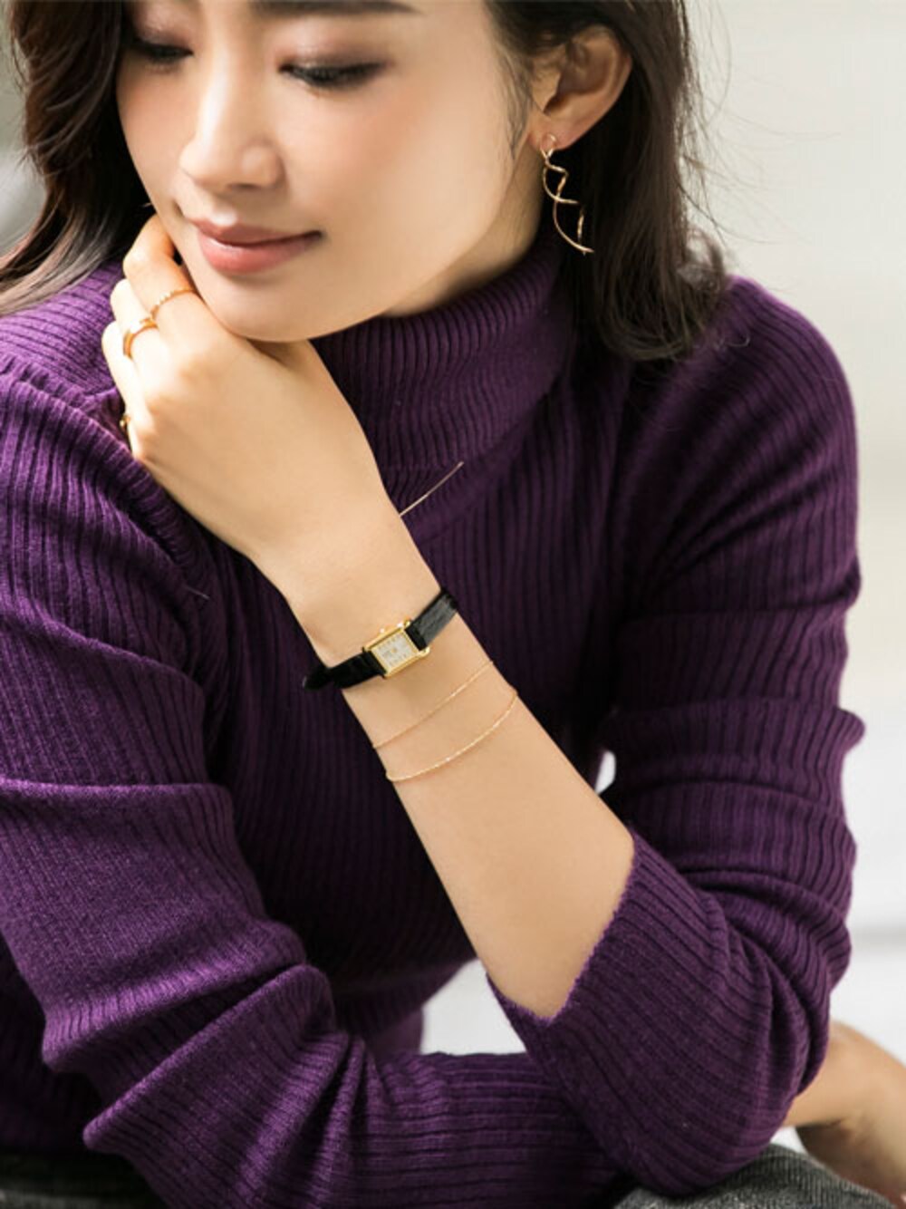 ゴールド系のブレスレット、ゴールド系のイヤリング、ブラック系のアナログ腕時計を着用したレディースの冬コーディネートの1枚目の写真