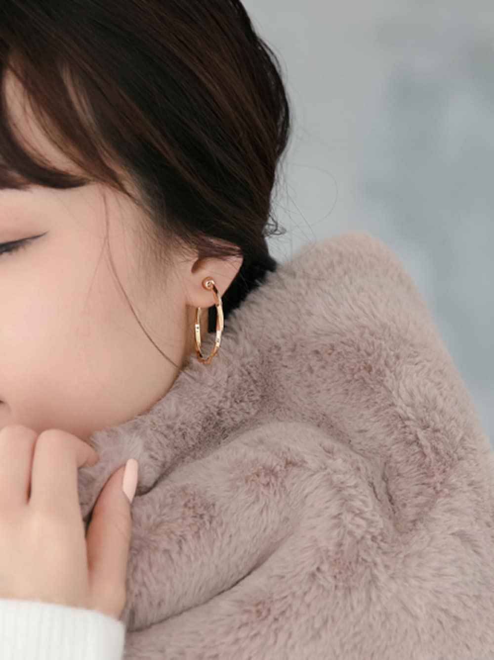 ゴールド系のイヤリングを着用したレディースの冬コーディネートの1枚目の写真