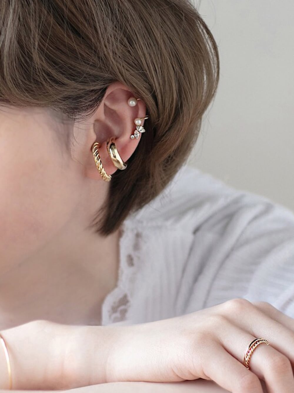 ゴールド系のイヤーカフ、ゴールド系のイヤーカフ、ゴールド系のイヤーカフを着用したレディースの春コーディネートの1枚目の写真