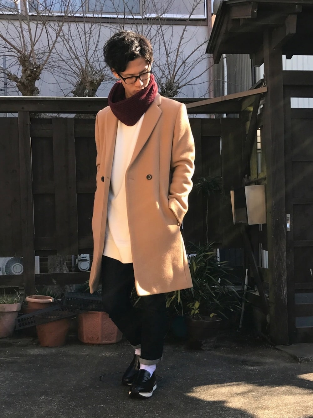 ベージュ系のチェスターコート、ホワイト系のスウェット、ブルー系のデニムパンツを着用したメンズの冬コーディネートの1枚目の写真