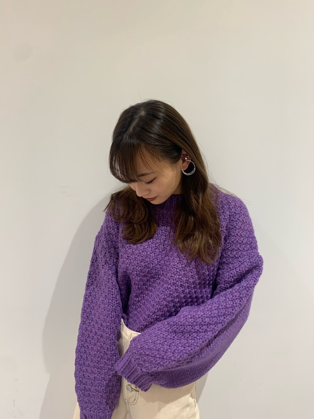 パープル系のニット/セーター、シルバー系のピアス（両耳用）を着用したレディースの秋コーディネートの1枚目の写真