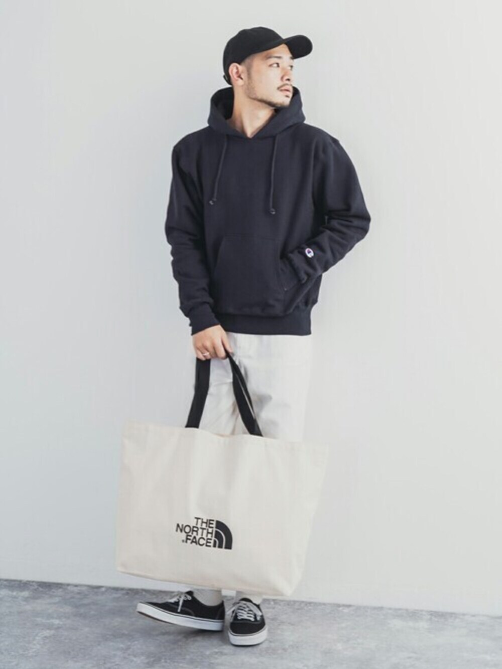 「トートバッグ、パーカー、ストリート、Champion、THE NORTH FACE、ノースフェイス、春コーデ、northface、チャンピオン パーカー」｜「Championの【Champion】Reverse Weave フーディー プルオーバーパーカー C5-U101（パーカー、ブラック系）」を使った、Rocky Monroeさん（メンズ・175cm）の春コーディネートの1枚目の写真