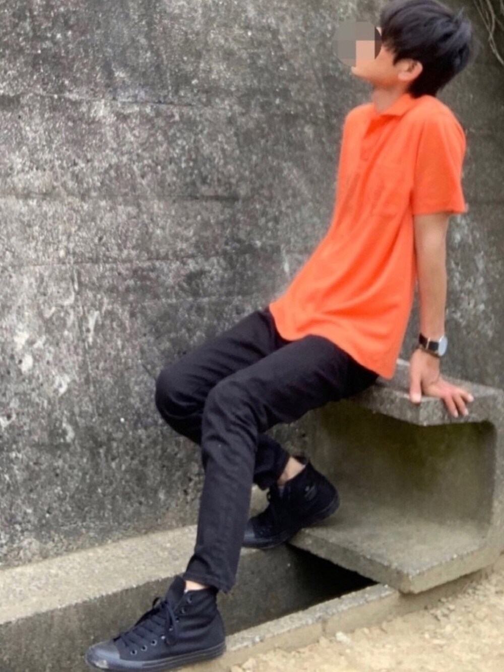 ブラック系のデニムパンツ、ブラック系のスニーカー、オレンジ系のポロシャツを着用したメンズの夏コーディネートの1枚目の写真