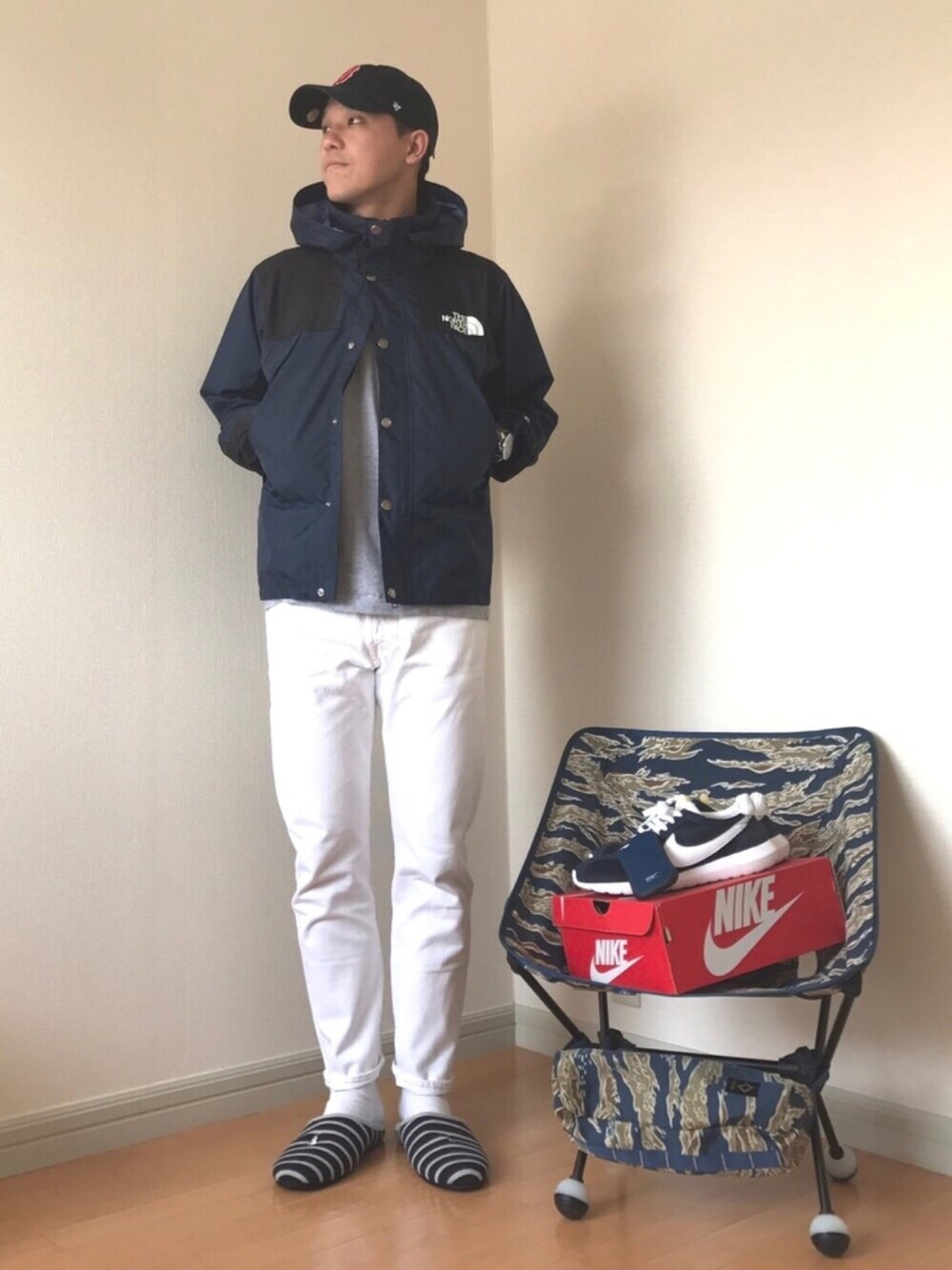 ブルー系のマウンテンパーカー、ホワイト系のデニムパンツ、ブルー系のスニーカーを着用したメンズの冬コーディネートの1枚目の写真