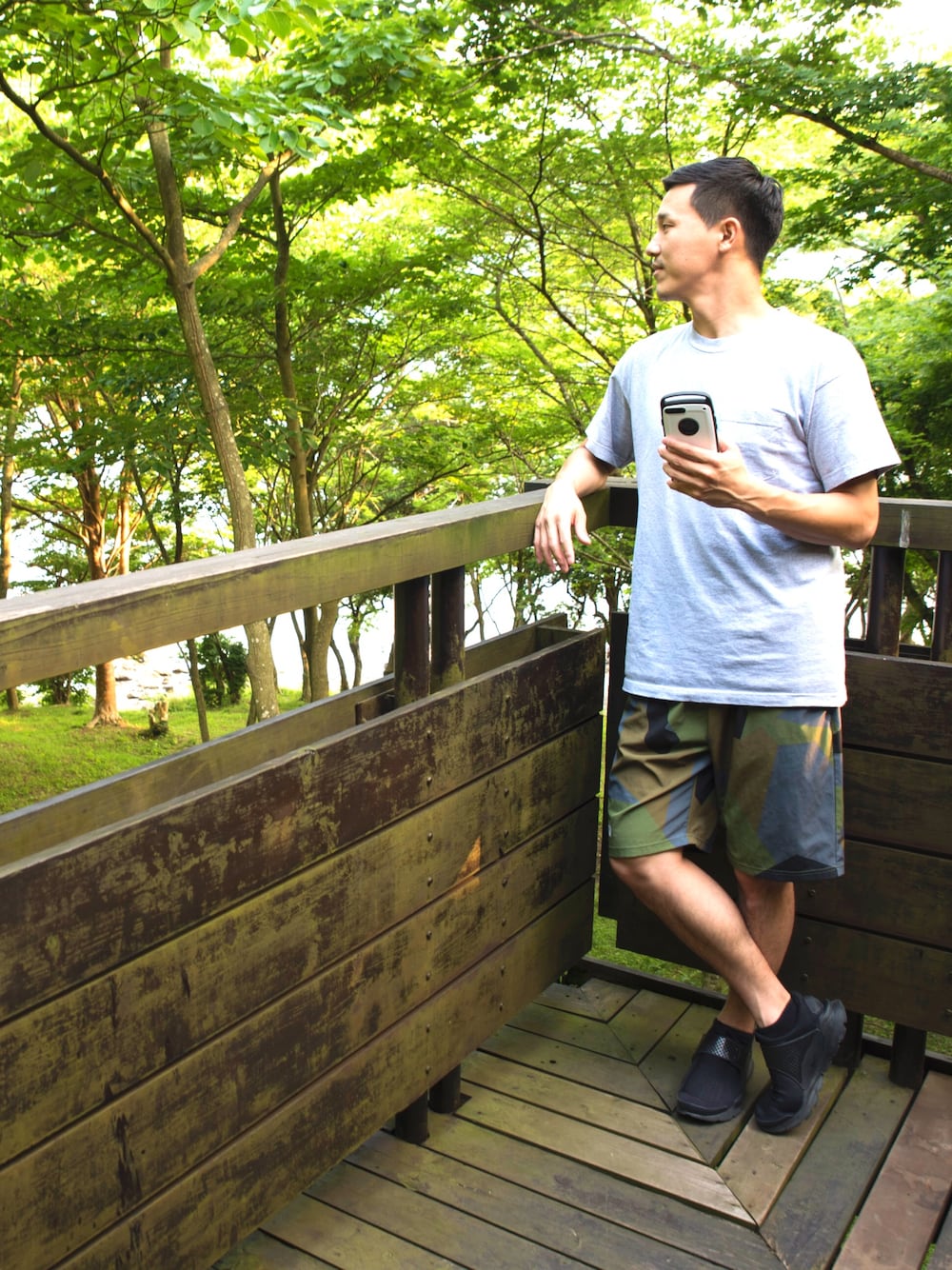 グレー系のTシャツ/カットソー、グリーン系のパンツ、ブラック系のスニーカーを着用したメンズの夏コーディネートの1枚目の写真