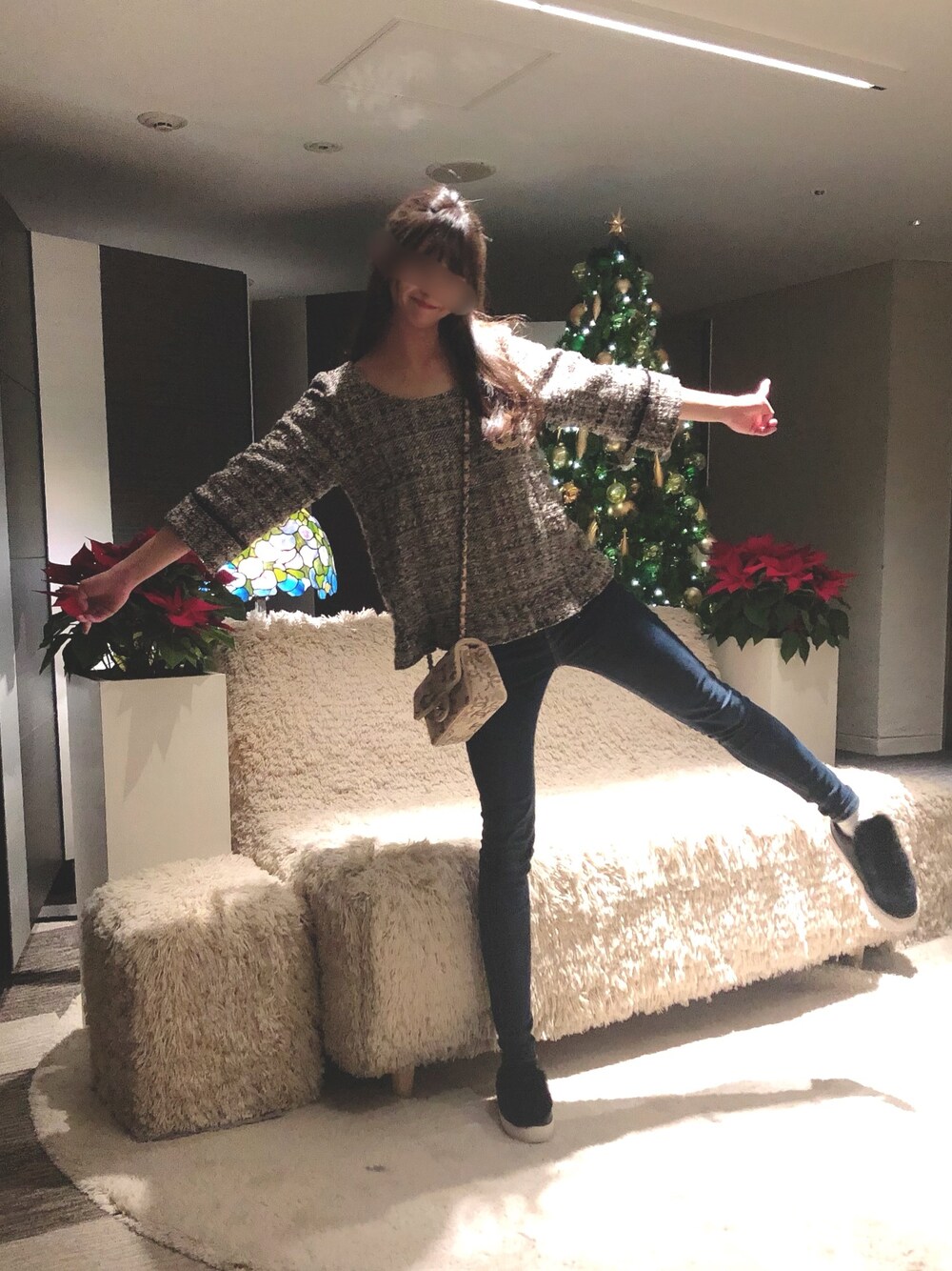 ピンク系のショルダーバッグ、ブラック系のトップス、ブルー系のデニムパンツを着用したレディースの秋コーディネートの1枚目の写真