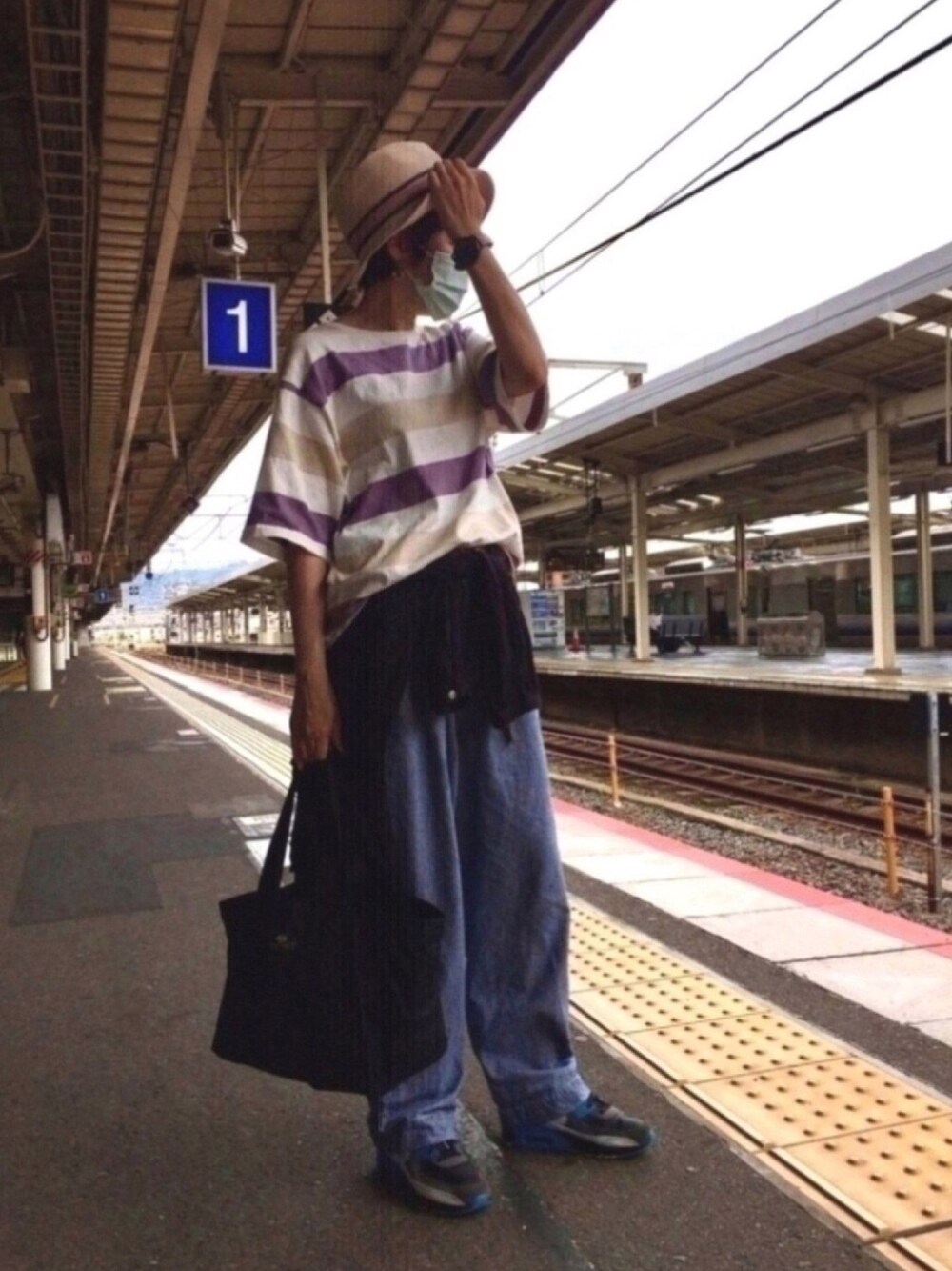 パープル系のTシャツ/カットソー、ブルー系のデニムパンツ、ブラック系のスニーカーを着用したレディースの夏コーディネートの1枚目の写真