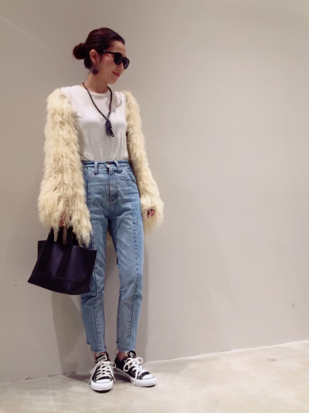 ホワイト系のカーディガン/ボレロ、ホワイト系のTシャツ/カットソー、ブルー系のデニムパンツを着用したレディースの秋コーディネートの1枚目の写真