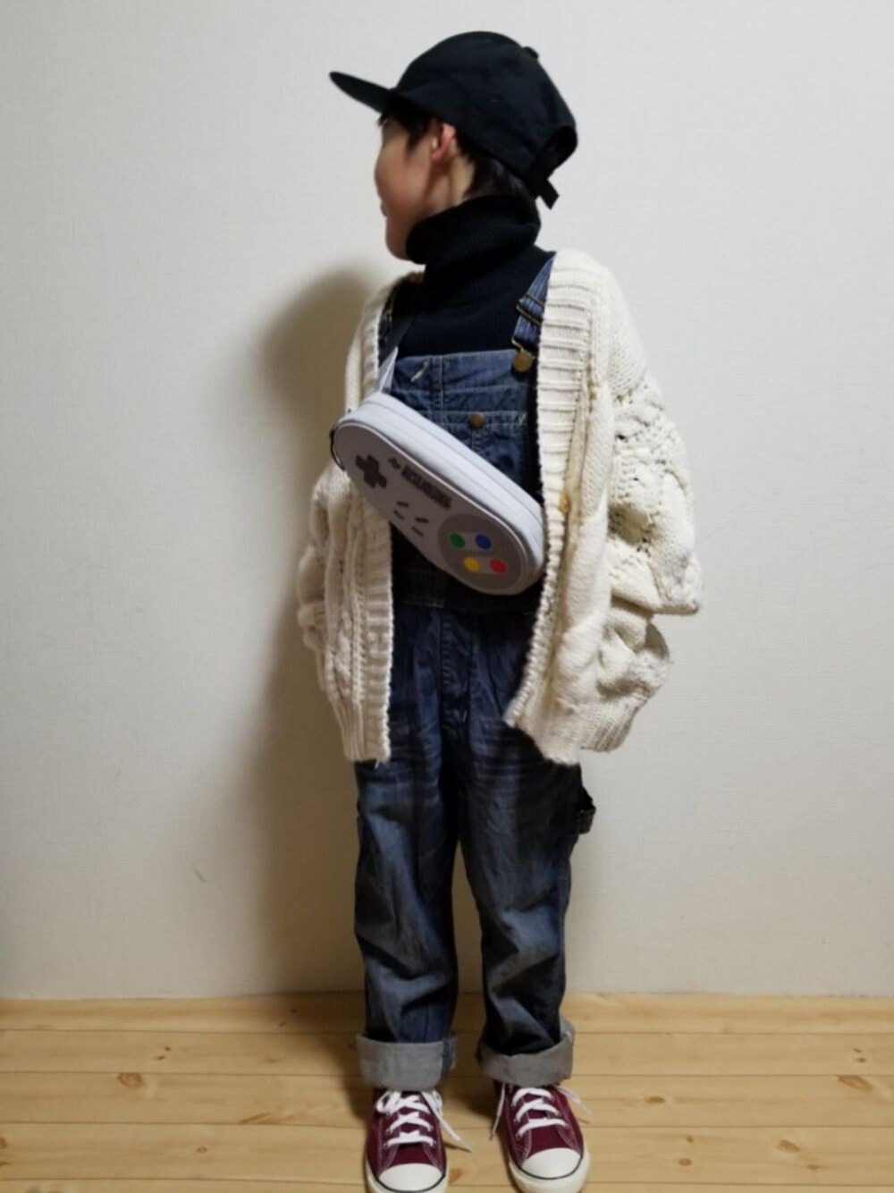 ホワイト系のニット/セーター、ブラック系のトップス、ブルー系のサロペット/オーバーオールを着用したキッズの冬コーディネートの1枚目の写真