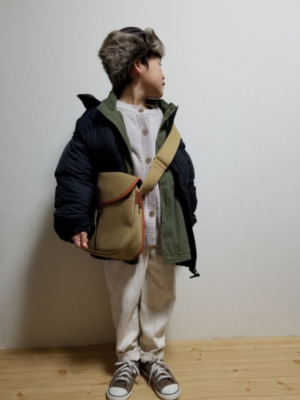 ブラック系のダウンジャケット/コート、ベージュ系のニット/セーター、グリーン系のモッズコートを着用したキッズの冬コーディネートの1枚目の写真