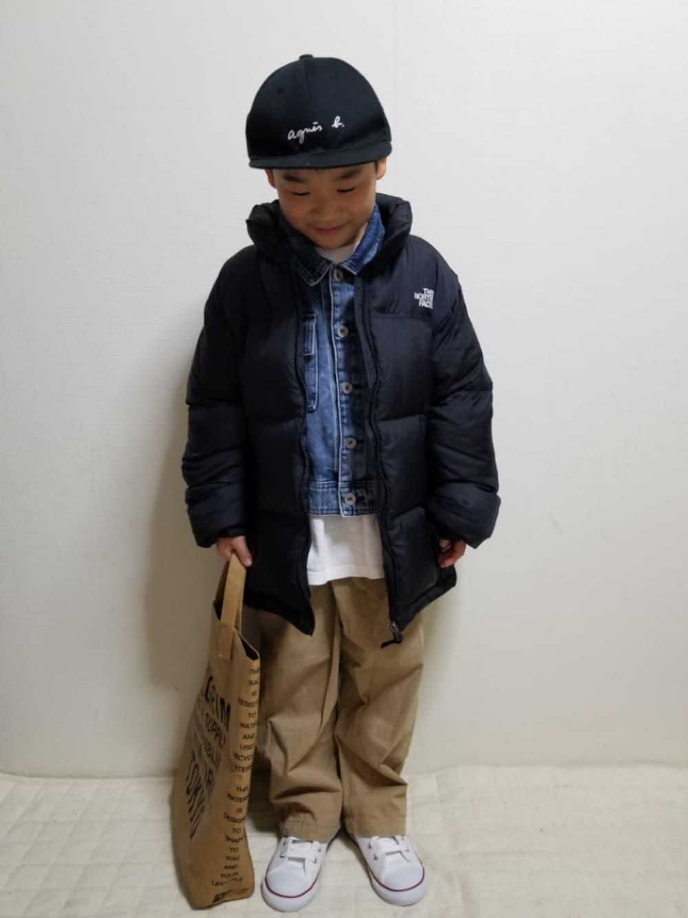 ブラック系のダウンジャケット/コート、ブルー系のデニムジャケット、ホワイト系のTシャツ/カットソーを着用したキッズの冬コーディネートの1枚目の写真