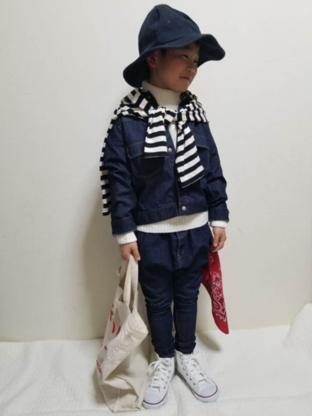 ホワイト系のニット/セーター、ブルー系のデニムジャケット、ブラック系のTシャツ/カットソーを着用したキッズの冬コーディネートの1枚目の写真