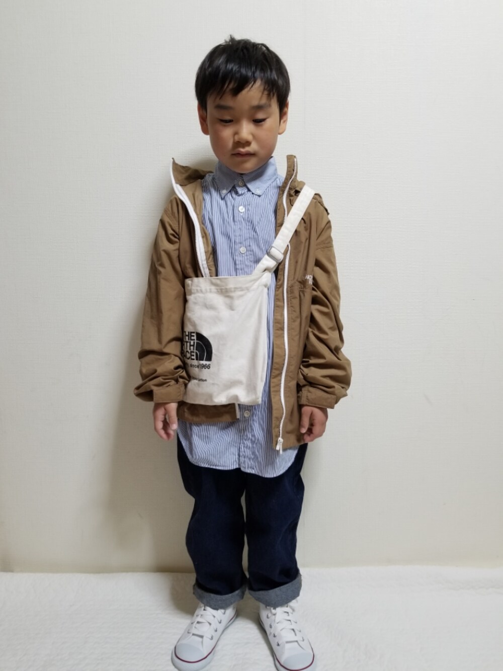 ベージュ系のブルゾン、ブルー系のシャツ/ブラウス、ブルー系のデニムパンツを着用したキッズの冬コーディネートの1枚目の写真