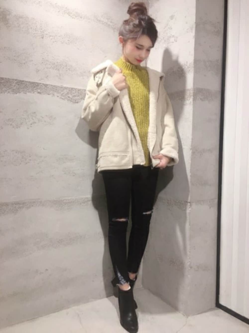 ホワイト系のミリタリージャケット、イエロー系のニット/セーター、ブルー系のデニムパンツを着用したレディースの冬コーディネートの1枚目の写真