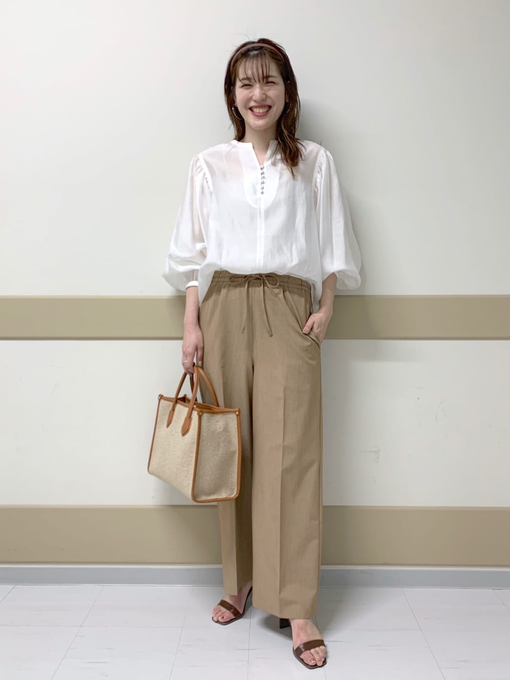 ブラウン系のその他パンツ、ブラウン系のサンダル、ベージュ系のトートバッグを着用したレディースの春コーディネートの1枚目の写真