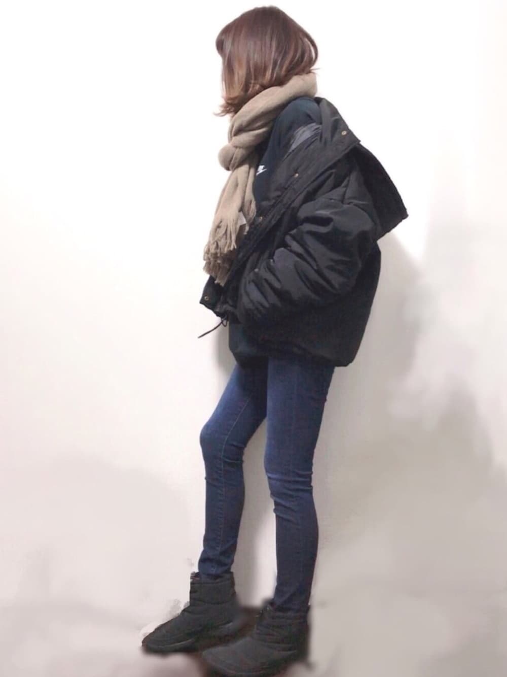 ブラック系のスウェット、ブラック系のその他アウター、ブルー系のデニムパンツを着用したレディースの冬コーディネートの1枚目の写真