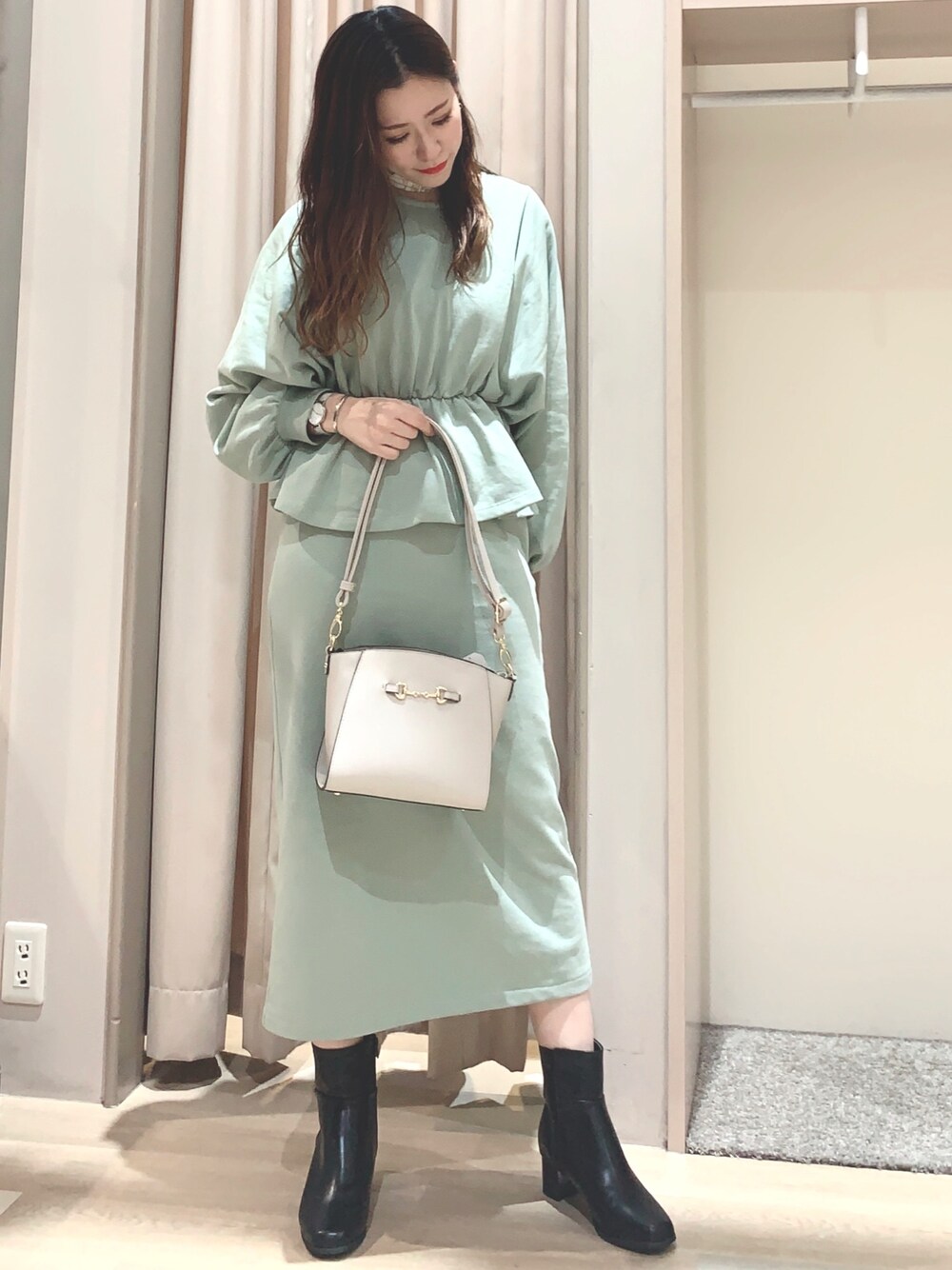 ブルー系のワンピース/ドレス、ベージュ系のショルダーバッグ、ブラック系のブーツを着用したレディースの冬コーディネートの1枚目の写真