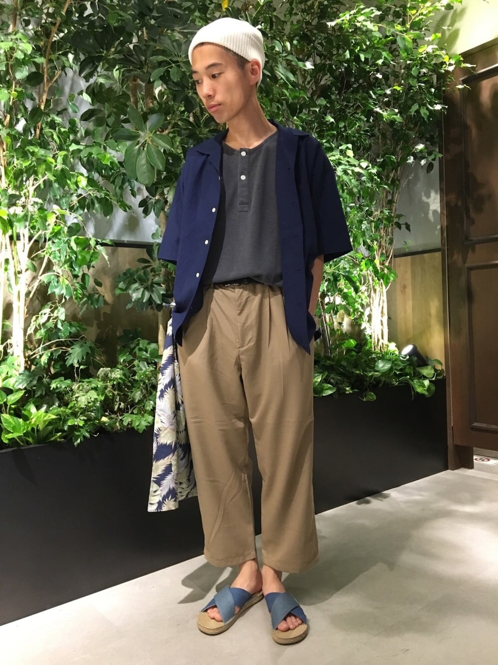 ブラック系のポロシャツ、ブルー系のシャツ/ブラウス、ベージュ系のスラックスを着用したメンズの夏コーディネートの1枚目の写真