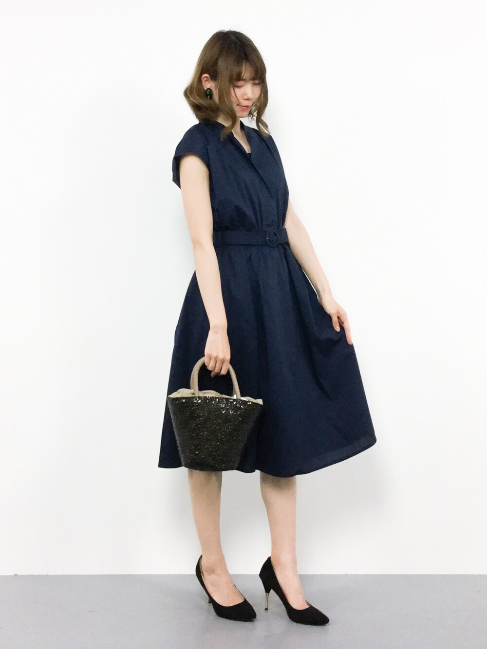 ブルー系のシャツワンピース、ブラック系のかごバッグを着用したレディースの春コーディネートの1枚目の写真