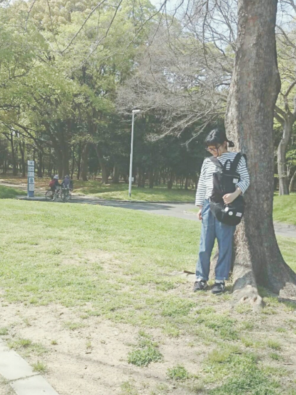 ホワイト系のトップス、ブラック系のスニーカー、ブルー系のデニムパンツを着用したレディースの春コーディネートの1枚目の写真