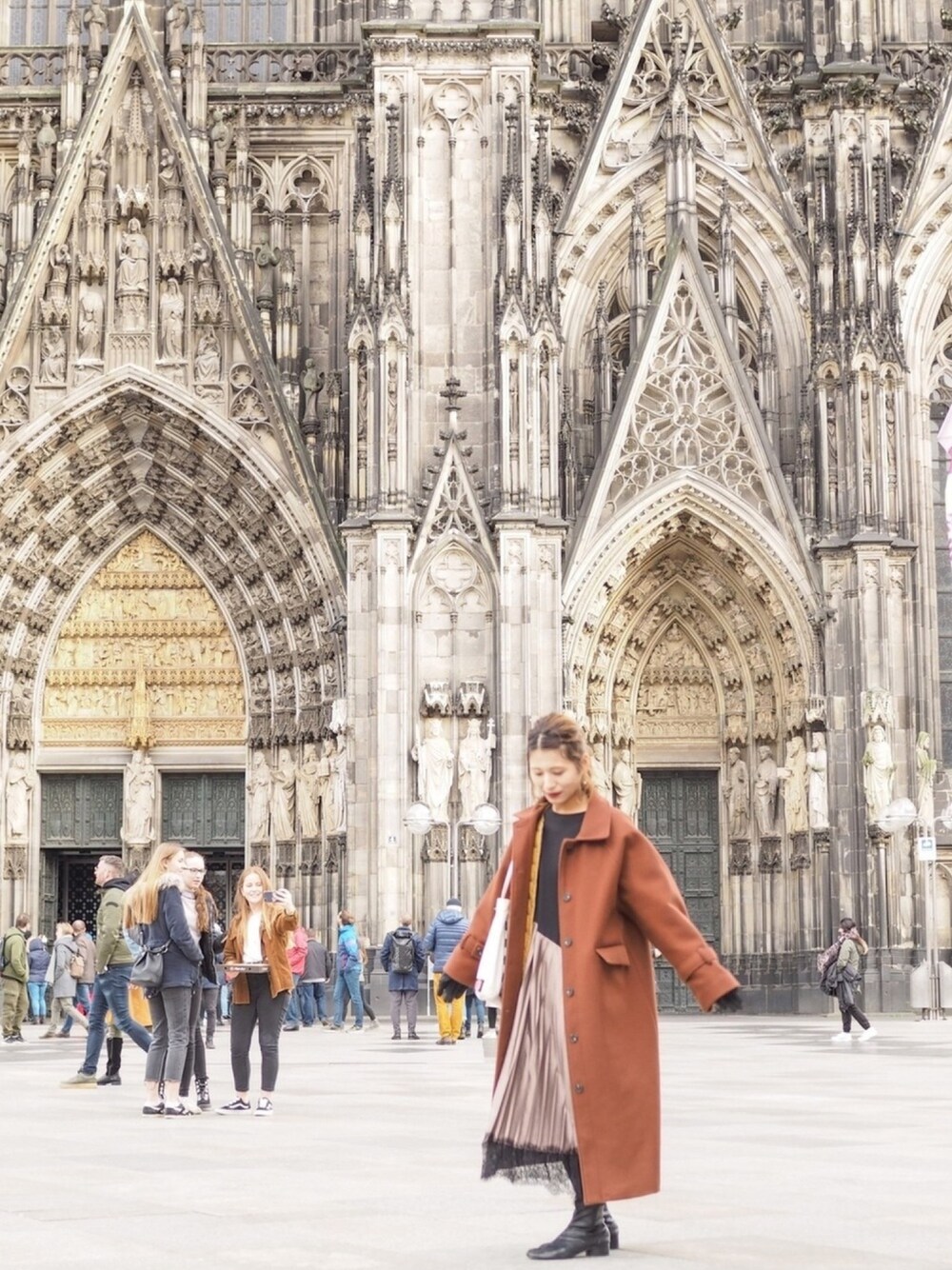 ブラウン系のその他アウター、ブラック系のワンピース、ブラック系のブーツを着用したレディースの春コーディネートの1枚目の写真